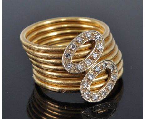 A yellow metal seven strand diamond dress ring, featuring two oval sections each set with ten single cut diamonds, diamond di