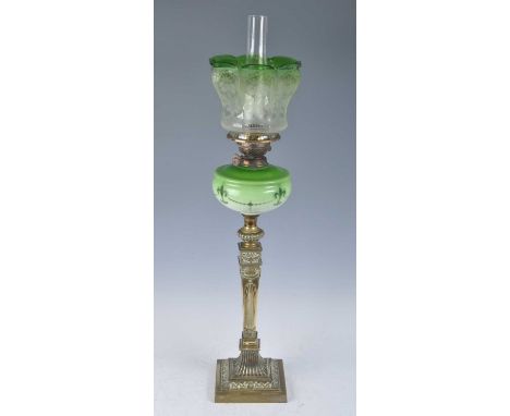 A Victorian brass oil lamp, having an acid etched green tinted glass shade above a green tinted milk glass font to a square t