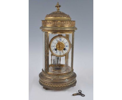 An early 20th century French gilt metal four-glass cylindrical mantel clock, having anthemion leaf cast frieze over enamel de