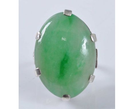 A white metal jadeite dress ring, featuring an oval jadeite cabochon in a six claw setting, jadeite dimensions approx 28 x 24