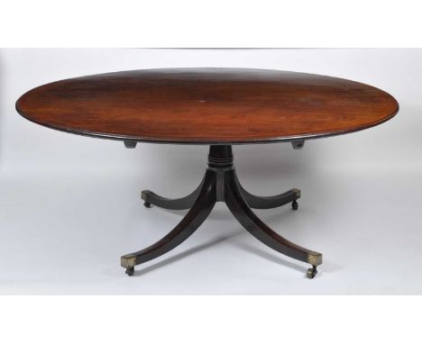 A late Georgian mahogany pedestal dining table, the oval tilt-top with boxwood stringing to a gun barrel ring turned column, 