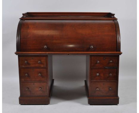 A Victorian mahogany twin pedestal cylinder desk, the top having three-quarter gallery over a cylinder enclosing pull-out wri