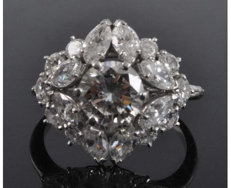 A Boucheron platinum and diamond oblong cluster ring, featuring a centre round brilliant cut diamond within a border of eight