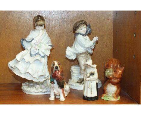 A Royal Doulton model of a spaniel holding a pheasant, a Royal Worcester snuffer in the form of a nun and two Coalport figure