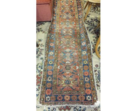 An Eastern runner with geometric and floral decoration, 252 x 70cm, (a/f, worn).