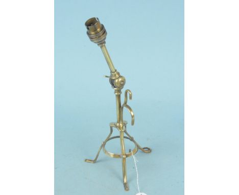 An Arts and Crafts adjustable brass table lamp in the manner of Benson raised on tripod supports, 30cm high overall