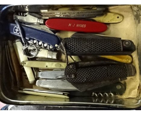 Black magic tin containing a number of various penknives including mother of pearl handles