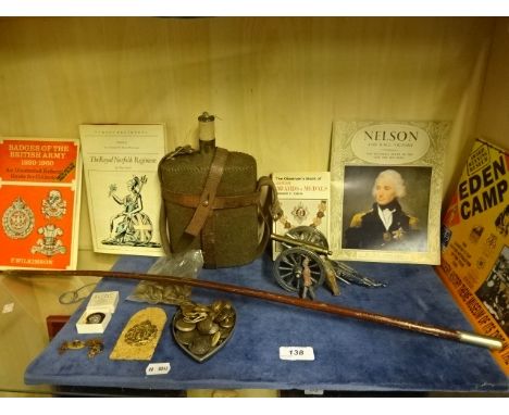 Collection of militaria to include books, water canteen, lead soldiers and cannon figure, buttons, badges, cufflinks, cane et