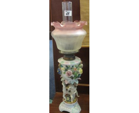 Sitzendorf porcelain double burner oil lamp with cherub mounts and relief floral decoration, frosted glass shade and clear ch