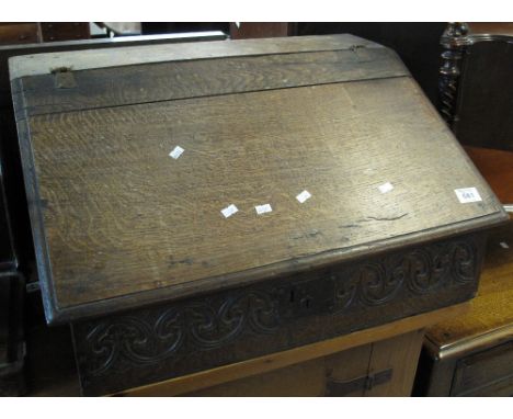 18th Century slope fronted oak clerk's desk with foliate carved decoration and interior shelf. 67cm wide approx. (B.P. 24% in