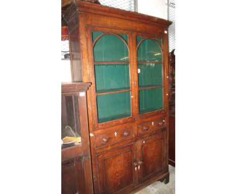 19th Century oak two door glazed bookcase unit having two drawers and blind panelled cupboard doors on bracket feet. (B.P. 24