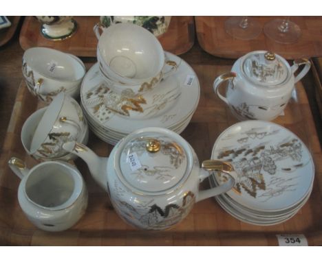 Tray of Japanese porcelain teaware, the cups with lithophane portrait bases on a white ground with gilded landscape scenes.(B