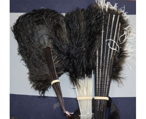 A black and white ostrich feather fan and two black ostrich feather fans, the former with silver foliate design on ebonised g