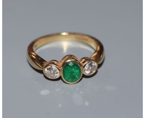 A three stone emerald and diamond ring, 18ct gold setting and shank, size J.