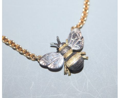 A yellow and white metal 'bee' pendant on 18ct yellow gold chain, gross 11 grams.