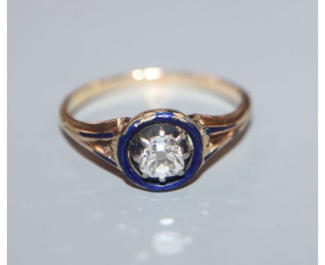 A late Victorian yellow metal solitaire diamond and blue enamel ring, size N.