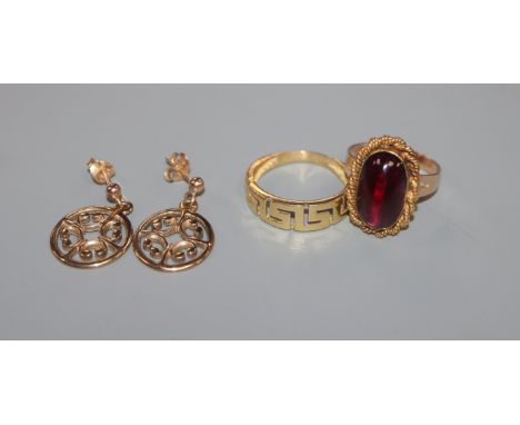 A pair of 9ct gold pierced disc ear studs, an 18ct gold Greek key pattern ring and a cabochon amethyst-set yellow metal ring.
