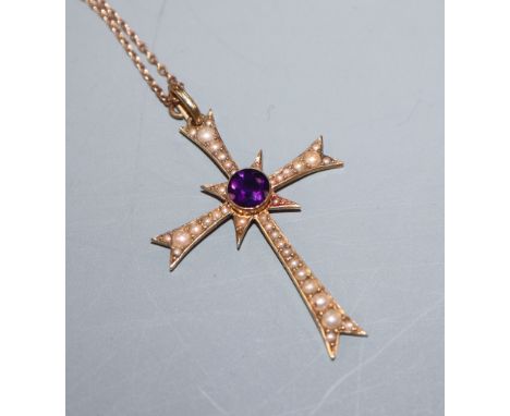 An Edwardian 15ct gold, amethyst and seed pearl set cross pendant, on a yellow metal fine link chain, pendant 36mm.
