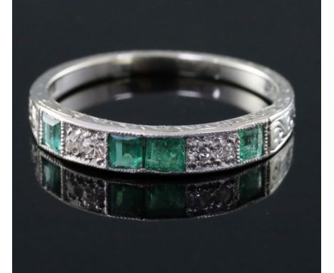 An 18ct and plat, emerald and diamond set half hoop ring, with engraved shank, size N.
