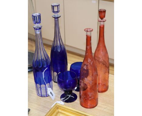 Two blue overlay glass decanters and stoppers, two ruby flask glass decanters and a pair of blue glass goblets, one stopper m