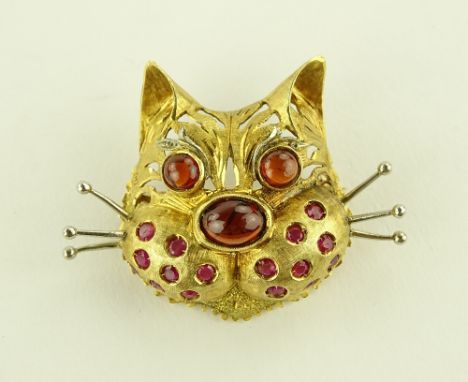An 18ct gold ruby and garnet set cat brooch, textured and pierced gold settings with round and cabochon cut stones, height 33