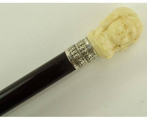 A Victorian lady's ebony walking cane with carved ivory child head finial.