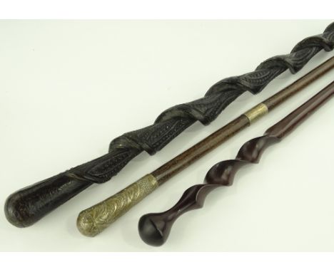 A 19th century spiral carved wood walking stick, an African hardwood stick with spiral twist handle and a continental stick w