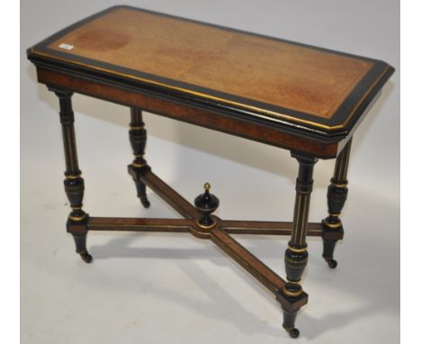 A Victorian amboyna and ebonised foldover card table with turned and fluted supports and cross stretcher, length 3'.