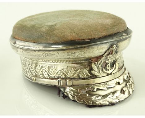 A George V silver pin cushion in the form of the Kings Military cap, makers marks S B & S Ltd., Chester 1910, length 7cm.