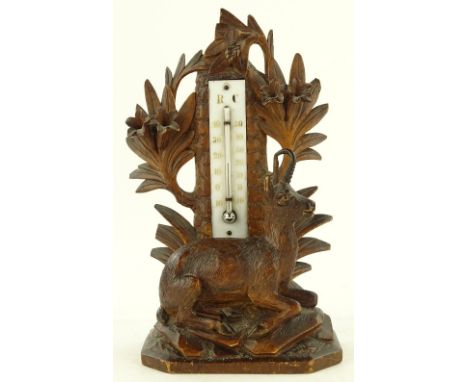 A 19th century Black Forest carved wood desk thermometer surmounted by a deer, height 23cm.