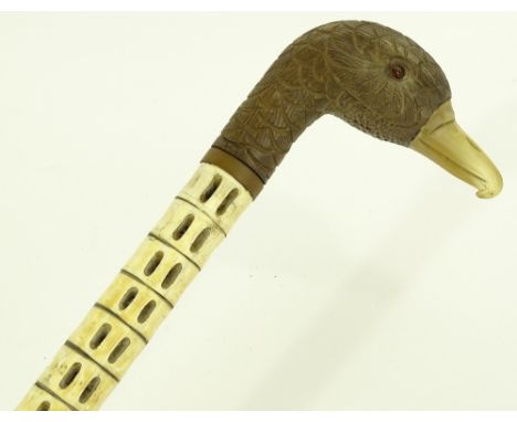 A shark vertebrae walking stick, with carved wood and horn duck's head handle, early 20th century.