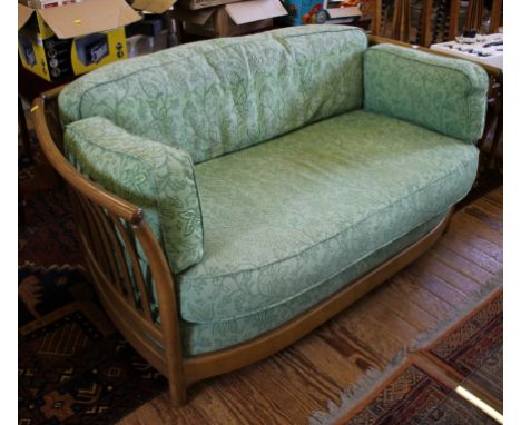 An Ercol oak framed two seat settee with rail back and arms, 148cm wide