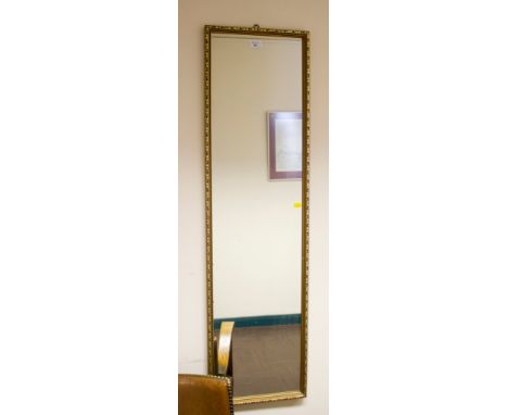 A giltwood full length wall mirror with foliate frame, 122cm x 33cm
