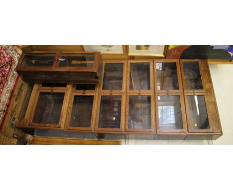 A 1920's oak stacking bookcase, each of the seven graduated sections with a pair of glazed doors on bracket feet, 89cm wide