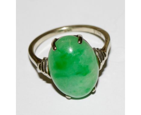 A platinum ring set with an oval cabochon jade stone