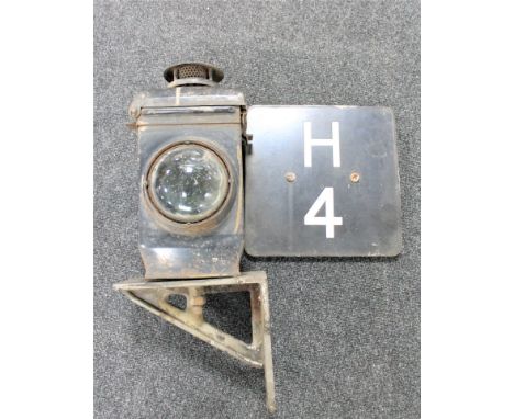 An early clear glass lens railway lamp on bracket and an enamelled railway sign "H4"