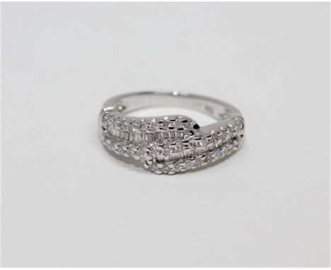 An 18ct white gold diamond set ring, set with brilliant and baguette-cut stones, size L.  CONDITION REPORT: 3.2g. 