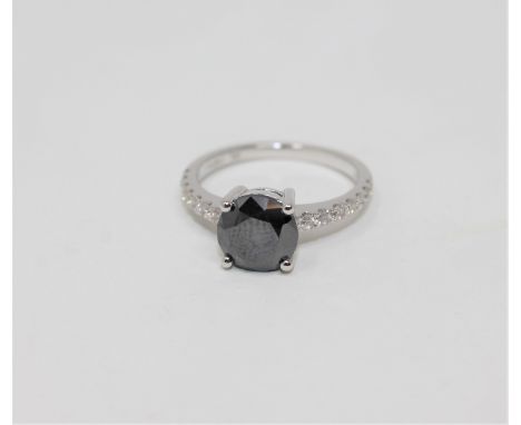 A 14ct white gold solitaire diamond ring, the principal black diamond weighing 1.85 carat, the shoulder-set diamonds weighing