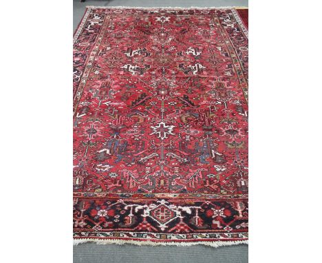 A Heriz rug woollen carpet on red ground, 343cm by 240cm