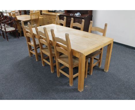 A contemporary oak dining table together with a set of six ladder back chairs 