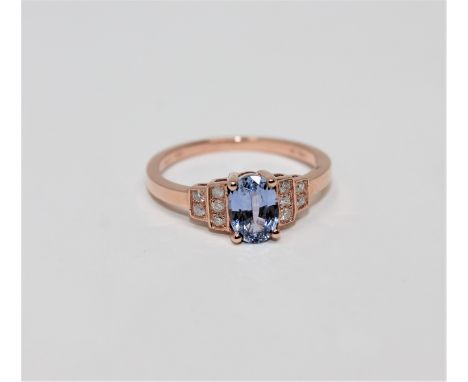 A 14ct rose gold sapphire and diamond ring, the oval-cut sapphire weighing 0.95 carat, the total diamond weight 0.1 carat, si