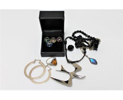 Two boxes of silver jewellery : charms, butterfly wing pendant on chain, silver and amber ring, jet ring and bracelet etc 