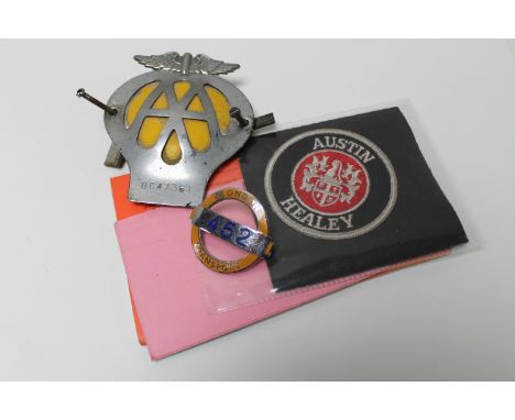 A box containing vintage AA badge, two cloth Austin Healey badges, together with a London Transport bus badge 