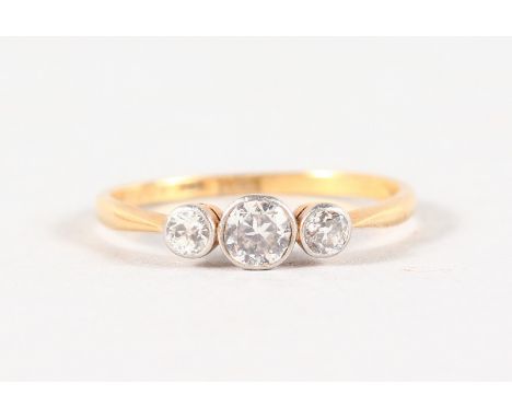 AN 18CT YELLOW GOLD THREE STONE DIAMOND RING.