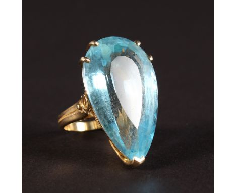 A LARGE AQUAMARINE PEAR SHAPED RING set in yellow gold.