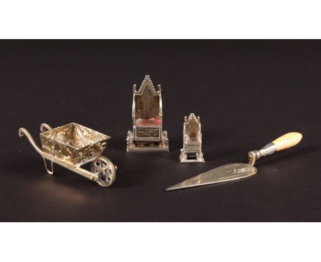 A MINIATURE TROWEL, WHEELBARROW and TWO THRONES (4).