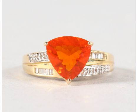 AN UNUSUAL 14CT YELLOW GOLD TRILLION CUT FIRE OPAL RING with diamond shoulders.