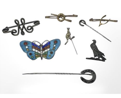 A group of brooches including an enamelled butterfly example, two equestrian-themed stick pins, etc 