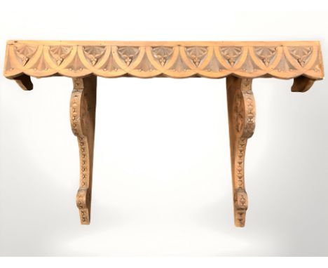 A carved pine wall shelf, width 69 cm.