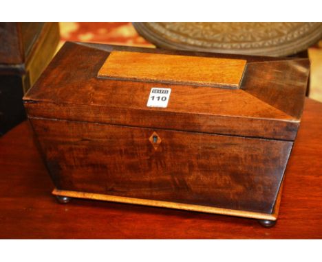 A 19th century mahogany tea caddy, of sarcophagus shape, with fitted compartments raised on squat bun feet, 31cm wide